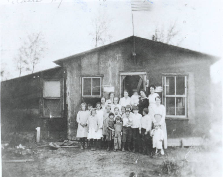 Photo of students and teachers posing outside school at Kildare near lumber station for Oval Wood Dish (OWD) Company.