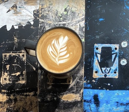 leafy foam design in coffee mug on a lacquered skateboard countertop.