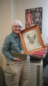 woman holding framed photo and archival box