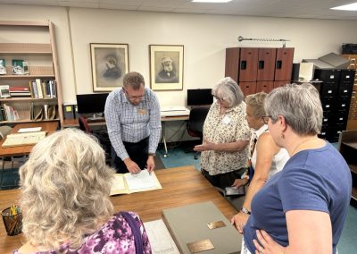 People gathered around table examining historic documents